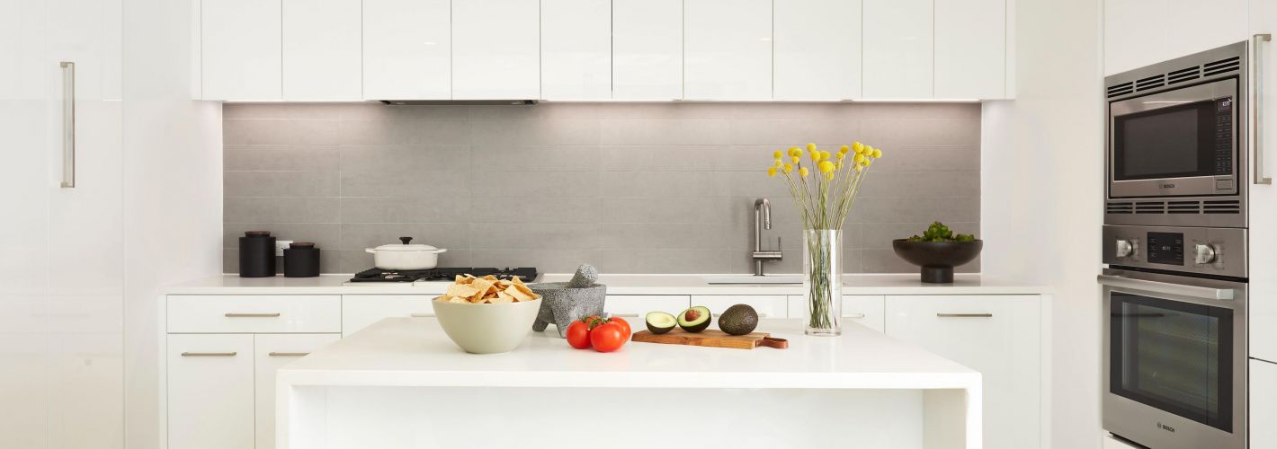 Kitchen showing island and all white cabinetry 